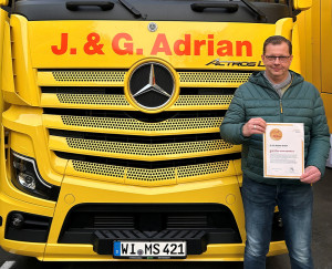Jens Mikoteit (Betriebsleiter) mit dem AMÖ-Zertifikat vor einem Adrian-LKW Jens Mikoteit (Betriebsleiter) mit dem AMÖ-Zertifikat vor einem Adrian-LKW
