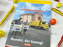 Unternehmenszeitschrift „Ein.Blick“ (2025/02) liegt auf dem Tisch umgeben von gelben und orangen Stiften